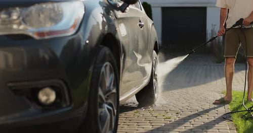 Man Wash Car with High Pressure Washer Selfservice Manual Car Wash Outdoors Summer Daytime