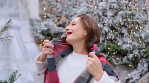 Woman Laughing near Christmas Trees with Fairy Lights