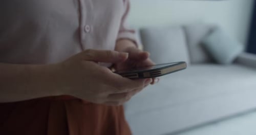 A Woman Typing on Mobile Phone Screen and Chatting in Living Room Woman's Hands Using Text Messages