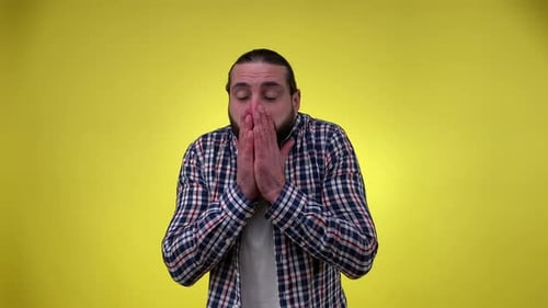 Man with Cold Sneezing Against Yellow Backdrop