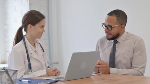 Female Doctor Talking with Patient in Clinic