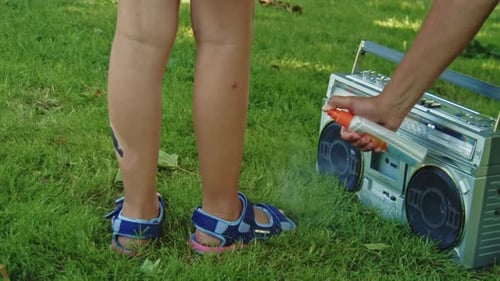 Father Protects Daughter with Mosquito Spray at Park Picnic