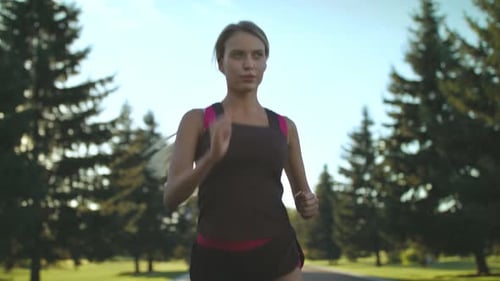 Active Woman Running on Path in Green Park
