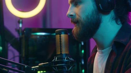 Young Adult with Beard Speaks into Microphone