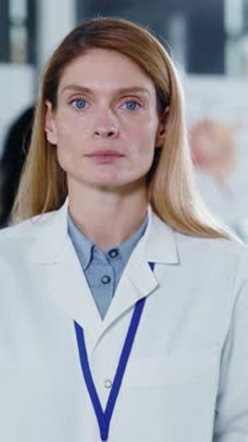 Woman in Lab Coat Looking Confidently Forward