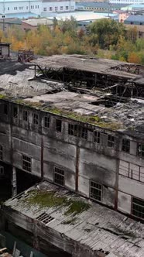 Old abandoned factory. Exterior of ruined buildings with many holes in the roof after military