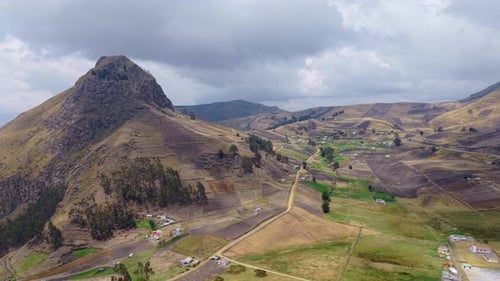 Mountain Peak Rising Above Patchwork Farmlands and Rural Dwellings Revealing Scenic Landscape of