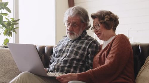 Senior Couple Using Laptop Together on Couch