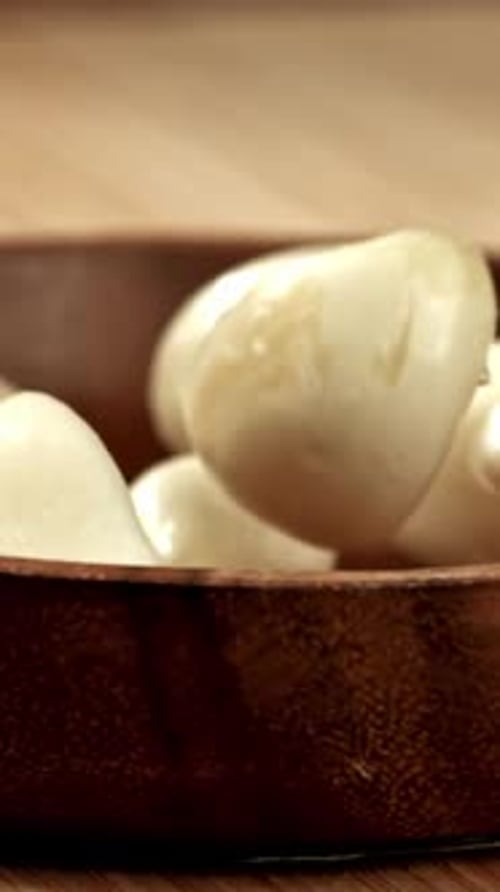 Peeled Garlic Falls Into a Wooden Plate Filmed on a Highspeed Camera at 1000 Fps