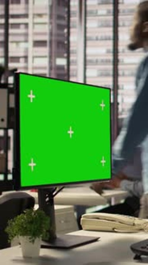 Vertical Video Female Director Seated at Workstation with Green Screen on Devices