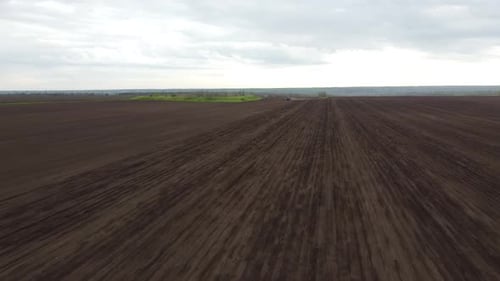Blue tractor OA working on the field in Ukraine
