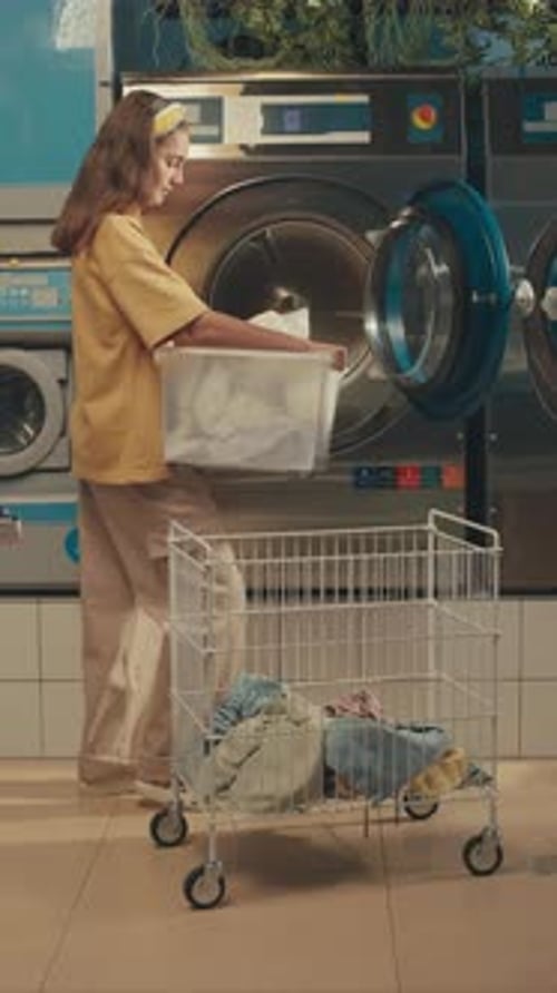 Young Adult Doing Laundry at Laundromat