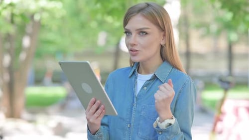 Portrait of Woman Doing Video Chat on Tablet Outdoor in Park