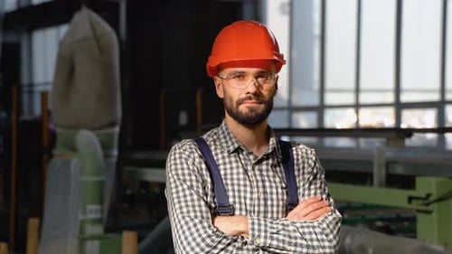 Young Man in Protective Helmet Working in Factory