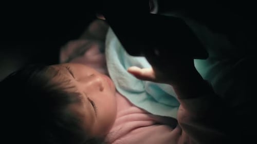 Jeune enfant absorbé par l'écran de la tablette numérique la nuit dans une chambre sombre