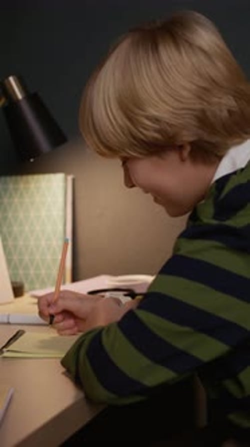 Child Studies At Desk Under Lamp At Night