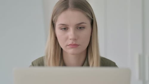 Close Up of Blonde Woman Reacting to Loss on Laptop