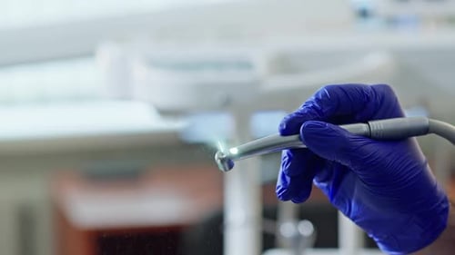 Zahnarzthand mit Bohrmaschine, Arzt testet, Arbeitswerkzeug, Nahaufnahme des Zahnbohrers