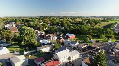 High and wide aerial overhead shot of small American town, village, establishing shot shows homes an