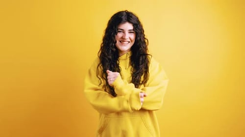Happy Young Woman Posing in Front of Yellow Background