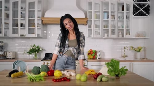 Woman Smiles in Bright Kitchen with Fresh Produce