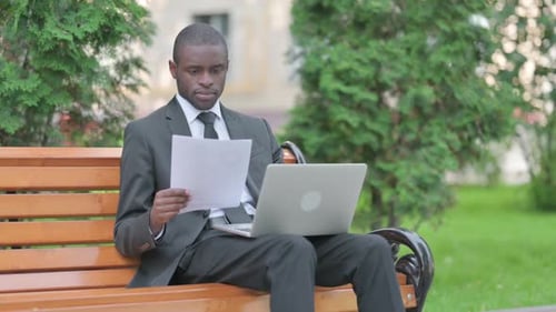 Young Adult Works on Laptop in Park