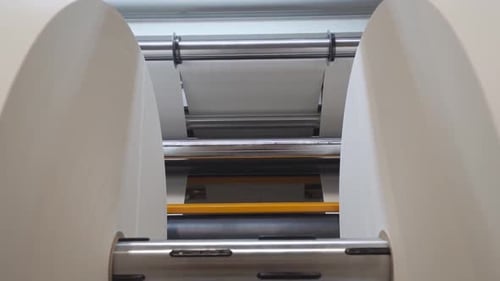 Huge Rolls Of Paper On Rolling Slitter For Custom Cutting In A Printing Factory. dolly-in shot