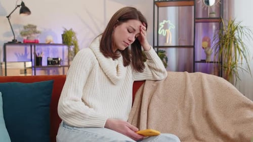 Woman Using Smartphone on Couch Indoors