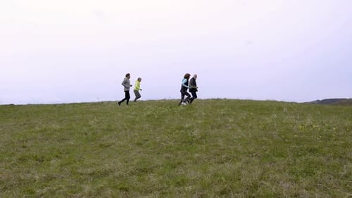 Group of Seniors Running Outside on the Green Hills