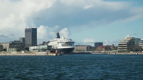 Scenic port view with large cruise ship docked. Ideal for travel documentaries or urban waterfront p