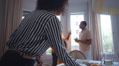 Family Prepares Dining Table in Bright Indoor Setting