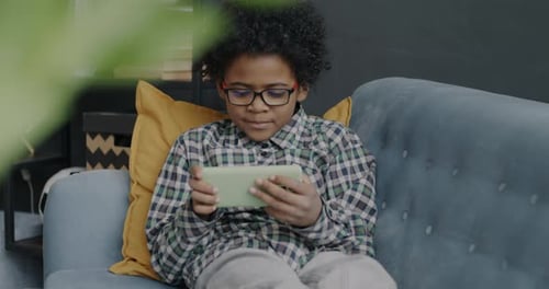 Child Plays on Phone at Home