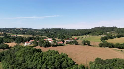 Aerial Of Idyllic Village In Countryside Plain Surrounded By Vegetations.