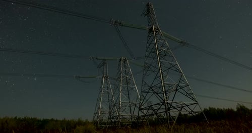 Nighttime View of Power Lines Against a Starry Sky in a Remote Area with Clear Visibility of