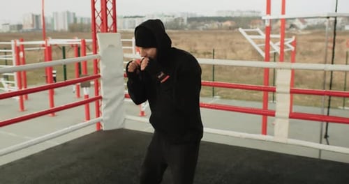 Young Adult Boxer Training in Outdoor Ring