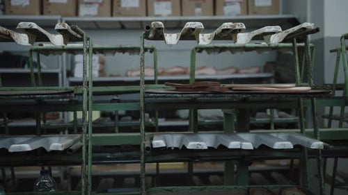 Sandal soles on a conveyor amidst shoe factory production line equipment