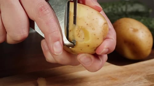 Close Up of Hands Peeling a Potato