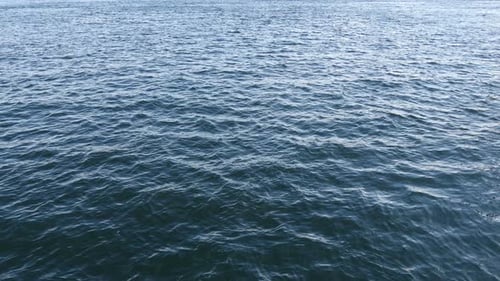 Turquoise water surface ripples reflecting summer sun outdoors in nature
