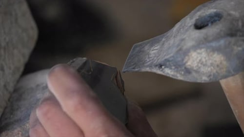 Slow motion video of a carpenter working on a wood design in his small carpentry workshop. Shaping a