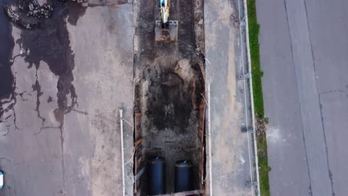 Aerial View of Excavator Laying Pipe Underground, Roadwork Construction