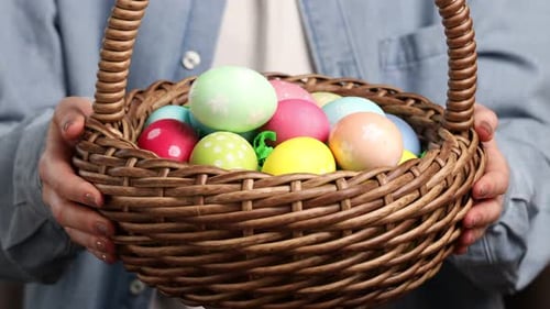 Frau hält Osterkorb mit bemalten Eiern in der Hand, Nahaufnahme