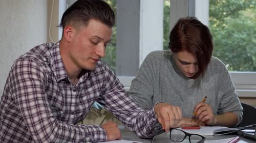 Exhausted Male Student Removing Glasses While Studying Hard