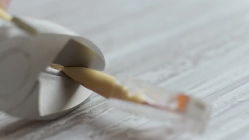 Pliers Stripping Yellow Cable Wire on Wood Surface