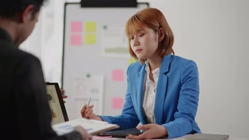 Businesswoman Explains Data Using Tablet in Workplace