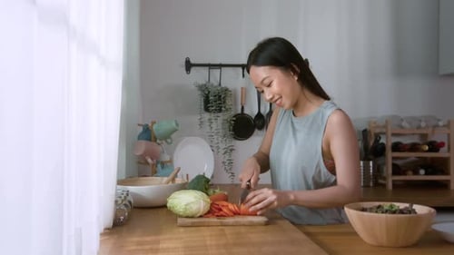 Woman Slicing Tomato Preparing Salad in Kitchen