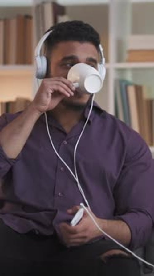 Man Listening to Music and Drinking Coffee at Home
