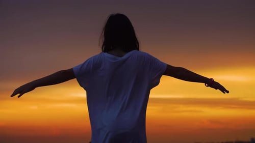 Child Silhouette with Arms Outstretched at Majestic Sunset