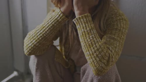 Close up panning of a despondent woman sitting on the floor