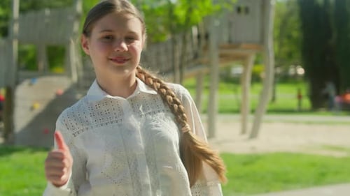 Girl Gives Thumbs Up in Park