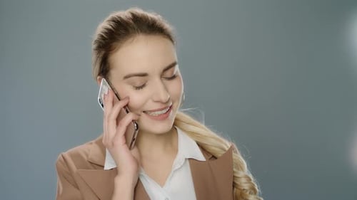 Happy Business Woman Calliing Mobile Phone in Studio. Smiling Girl Using Smartphone